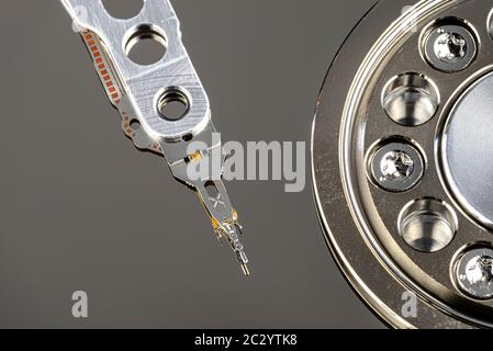 Macro shot of a magnetic needle on a hard disk platter, open HDD disk, perfectly clean surface, top view. Stock Photo