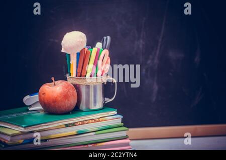 Back to school background with books and apple over blackboard. Stock Photo