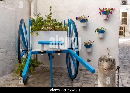 A wooden car painted white and blue decorated with flowers in Polignano a Mare. Apulia, Italy Stock Photo