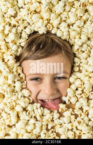 Creative portrait of a boy with his face surrounded by popcorn. Stock Photo