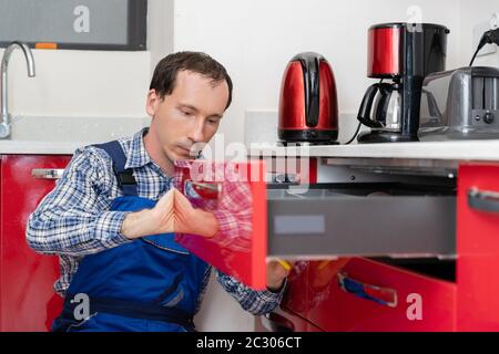 Close-up Of A Young Male Carpenter Installing Drawer Stock Photo