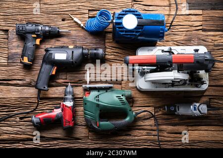 Various Power Tools Laying On Wooden Desk Stock Photo