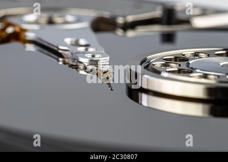 Macro shot of a magnetic needle on a hard disk platter, open HDD disk, perfectly clean surface. Stock Photo