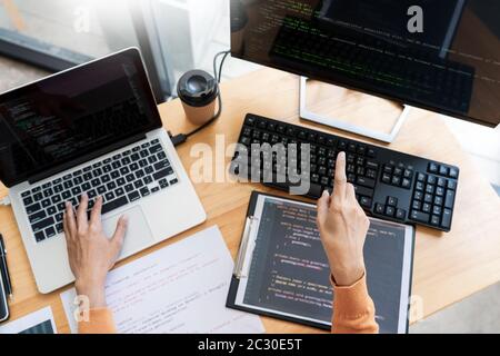 Pensive programmer working on on desktop pc programming code technologies or website design at office Software Development Company. Stock Photo