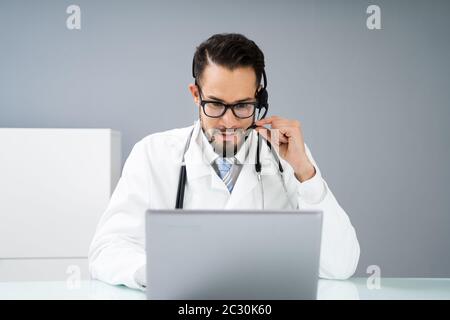 Close-up Portrait Of Confident Receptionist Using Headset In Hospital Stock Photo