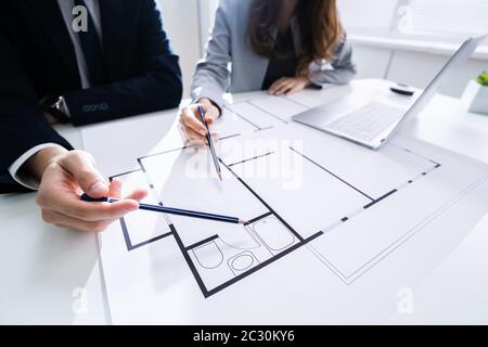 Close-up Of Two Architects Hands Working On Blueprint Stock Photo