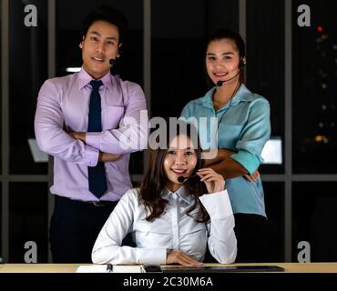 Late Night Environment, Potrait of friendly Call centre operator team with headsets in a call center customer service and technical support. Using for Stock Photo