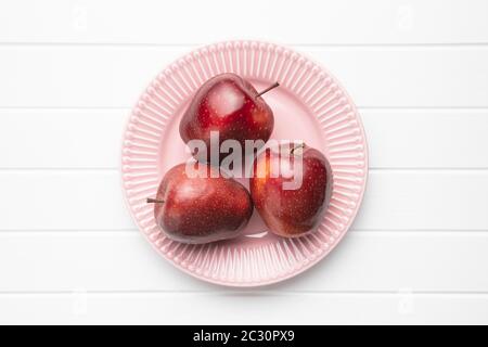 Three ripe red apples on plate. Top view. Stock Photo