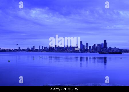 Iconic Seattle Skyline From Across The Puget Sound During A Dramatically Cloudy Dawn Stock Photo
