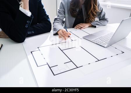 Close-up Of Two Architects Hands Working On Blueprint Stock Photo