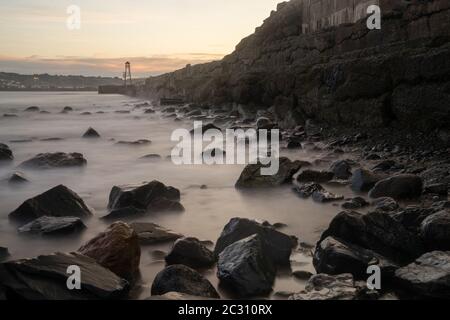 Beautiful view to rocky waterbreak in Oamaru, New Zealand with golden sunset. Stock Photo