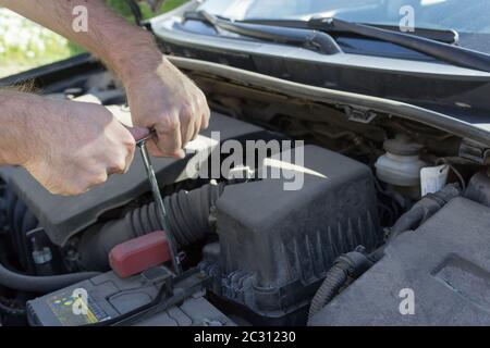 Mechanic at work, Close up detail of car engine under the open hood. Stock Photo
