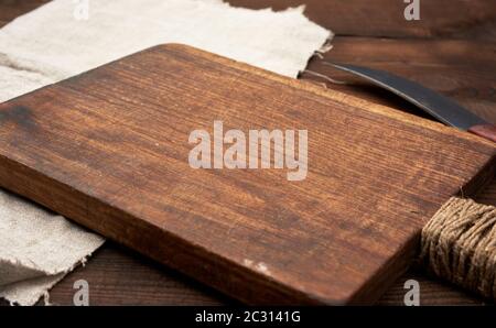 very old empty wooden rectangular cutting board and knife, close up Stock Photo
