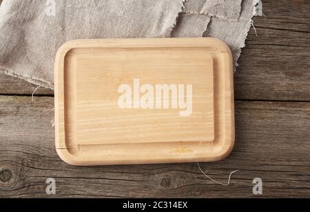 light beige rectangular empty cutting kitchen board on a wooden background from old boards, top view Stock Photo
