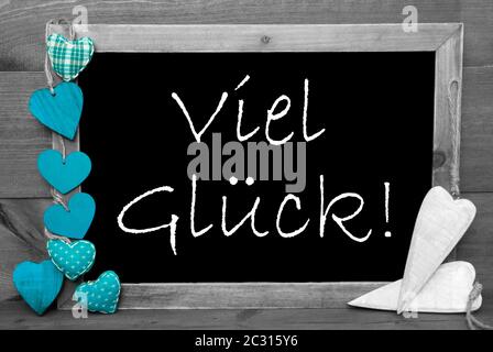 Balckboard With German Text Viel Glueck Means Good Luck. Gray Wooden Background With Colored Turqouise Heart Decoration Stock Photo