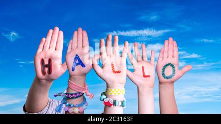 Children Hands Building Colorful German Word Hallo Means Hello. Blue Sky As Background Stock Photo