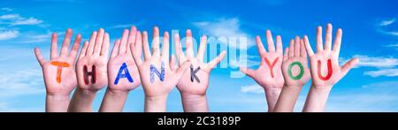 Many Children Hands Building Colorful Word Thank You. Blue Sky As Background Stock Photo