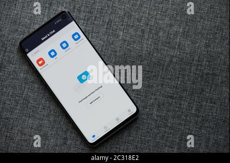 New-York , USA - June 18 , 2020: Using zoom meeting mobile app for group chat on smartphone in gray background Stock Photo