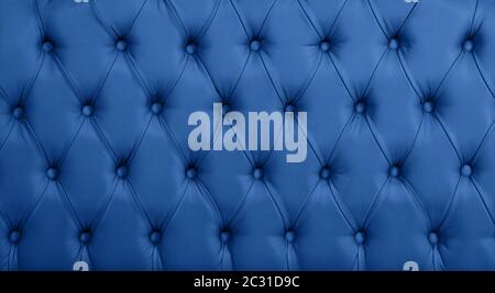 Close up background texture of dark blue capitone genuine leather, retro Chesterfield style soft tufted furniture upholstery with deep diamond pattern Stock Photo