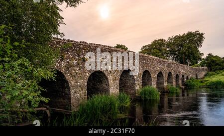 Old 12th century stone arch bridge over a river. Count Meath, Ireland Stock Photo