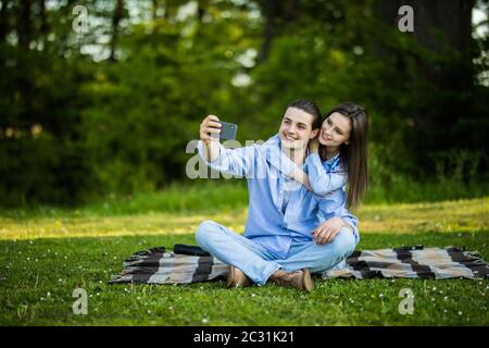 Embracing Couple Sitting On A Blanket.