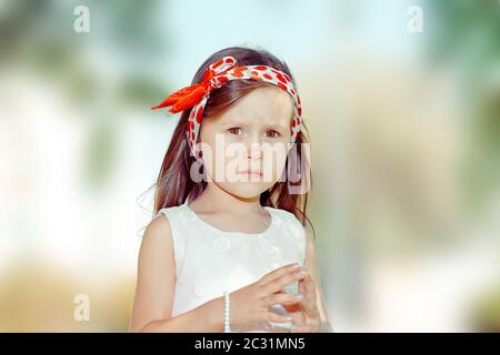 Portrait of a confident girl looking at camera unhappy and upset outdoors green tree park on background Stock Photo