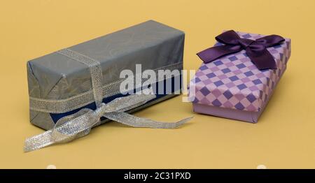 Beautiful colorful gift boxes with bows and silver glitter ribbon on yellow background Stock Photo
