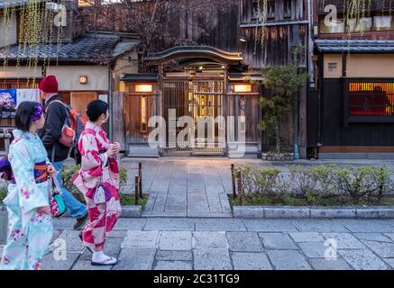 Japanese girls in kimono walking in the street of Gion, Kyoto, Japan at dusk. Stock Photo