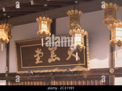 Golden lanterns hanging at the entrance of the Daikokutô which houses the deity of the wealth Daikok Stock Photo