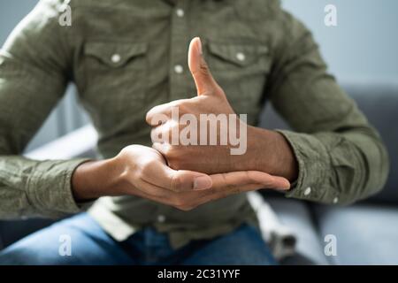 Man Using Sign Language To Communicate At Home Stock Photo