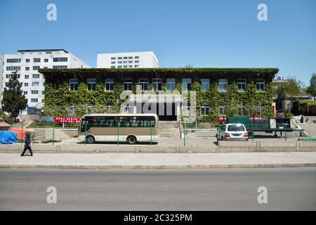 Pyongyang, North Korea - May 2, Administrative house in suburb of city, typical apartments house in background Stock Photo