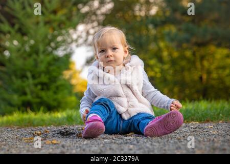 Happy children rejoices autumn weather and playing in the meadow in the park Stock Photo