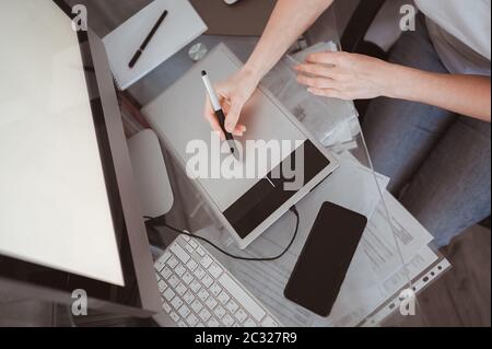 Workplace of photographer or graphic designer. Creative designer hands working on laptop with graphic tablet.  Stock Photo