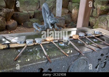 Dragon statue over purification fountain in Yaotomi Shrine on Take Island, Japan Stock Photo