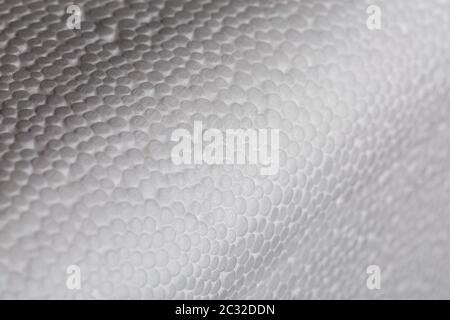 Simple close-up bumpy background of white polystyrene foam or styrofoam, white on white backdrop with selective focus and partial blur. Stock Photo