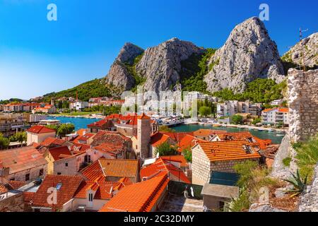 Sunny beautiful aerial view of Cetina river, mountains and red roofs of Old town in Omis, very popular tourist spot in Croatia Stock Photo