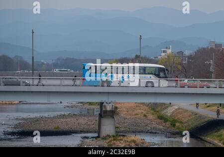 Vehicles on a bridge crossing across Kamo River, Kyoto, Japan Stock Photo