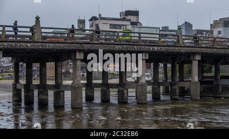 Vehicles on a bridge crossing across Kamo River, Kyoto, Japan Stock Photo
