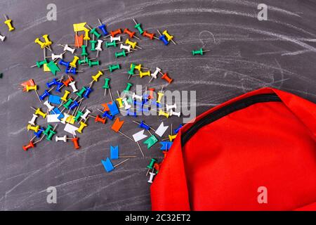 Back to school shopping backpack, on photo have red bag and colorful pin on blackboard and chalkboard Stock Photo