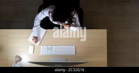 Late Night Environment. Top view of young adult friendly operator call center with headsets working hard at night. Using for 24 Hr. 7 days Call centre Stock Photo