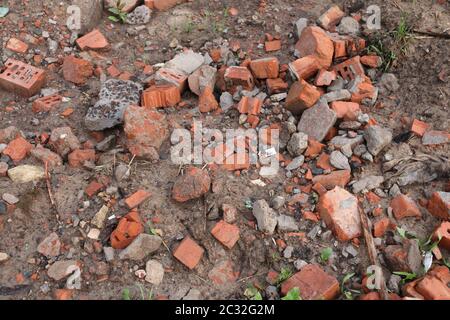 A broken brick lies on the wet ground. Construction waste. Mud Stock Photo