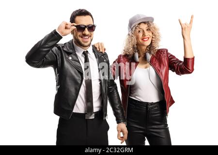 Young woman gesturing a rock and roll sign and leaning on a guy in a leather jacket and sunglasses isolated on white background Stock Photo