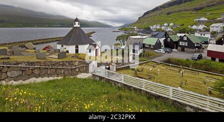 The small town of Haldarsvik with the octagonal church and view of the Atlantic, Faeroeer, Denmark Stock Photo