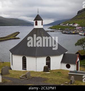 The octagonal church with a view of the Atlantic in the small town of Haldarsvik, Faeroeer, Denmark Stock Photo