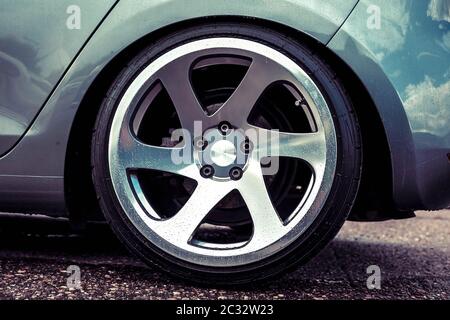 Alloy wheels of a sports car. Polished to shine. On a gray car. Closeup Stock Photo