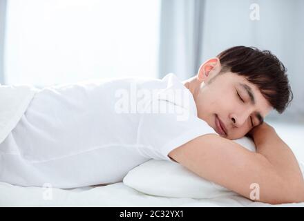 Handsome young man sleeping in bed Stock Photo