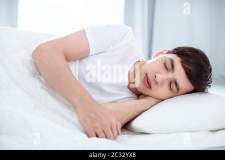 Handsome young man sleeping in bed Stock Photo