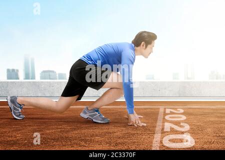 Asian runner man ready to run on the 2020 line. Happy New Year 2020 Stock Photo