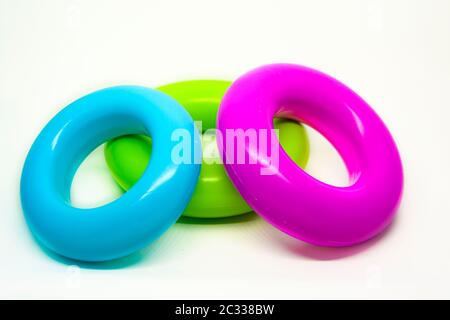 three colored plastic rings isolated on a white background. Children's toys for stacking. Preschool education and fun Stock Photo