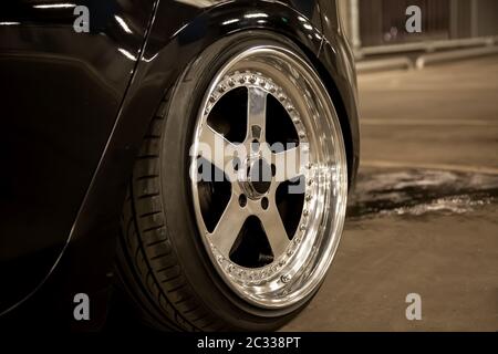 Alloy polished rims of a sports car. Wide wheels with stretched tires. Tuned low car Stock Photo